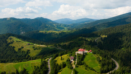 Beautiful colorful landscape in Ukraine - a ski resort with a background of a small residential area. Hotel on top of mountains