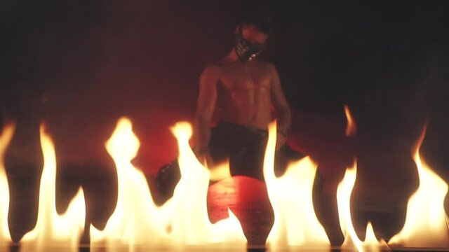 Sexy Man in mask dancing in fire
