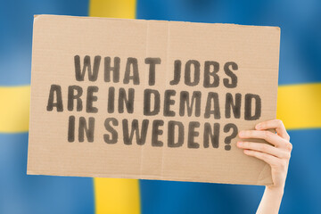The question " What jobs are in demand in Sweden? " on a banner in men's hand with blurred Swedish flag on the background. Work. Profession. Social security. Position. Occupation. Office. Specialist