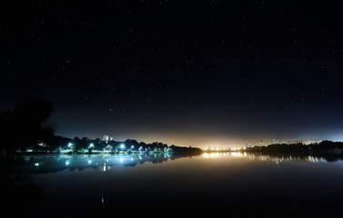 Lake in the night city under the starry sky.