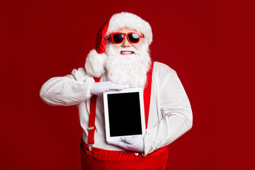 Portrait of his he attractive cheerful cheery fat white-haired Santa holding in hands demonstrating...