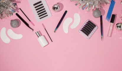 New year's flatley. Tools for eyelash extension on a pink background, top view. Patches, artificial...