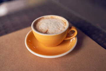 Cappuccino in the beautiful yellow ceramic cup. Beautiful foam and ceramic cup