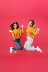 Image of excited caucasian women screaming and jumping