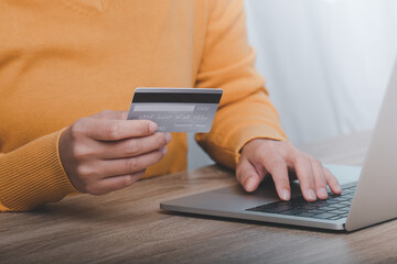 Hand holding credit card and using laptop. Online shopping concept