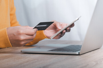 Online payment, Woman's hands holding a credit card and using smart phone for online shopping.