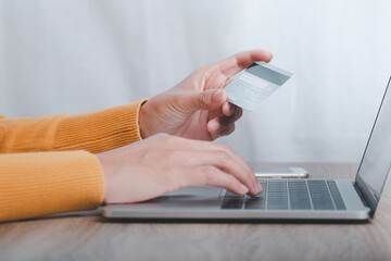 Hand holding credit card and using laptop. Online shopping concept