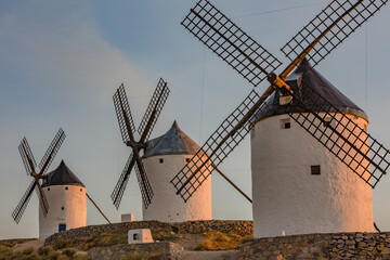 Beautiful white spanish windmill on the hill at fairy sunset near the castle in Consuegra, Toledo...