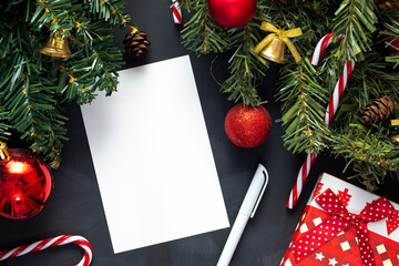 A list of Christmas gifts lies on a black table next to a decorated Christmas tree.