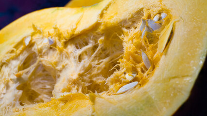 A large pumpkin is cut in half. Pumpkin seeds and insides. Harvesting from the garden. Cooking healthy food. Halloween dishes. Selective focus.