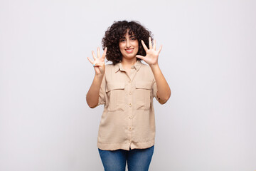  smiling and looking friendly, showing number nine or ninth with hand forward, counting down