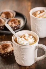Cup of hot cocoa with whipped cream and small Christmas stollen cookies