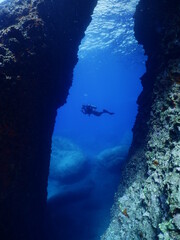 scuba divers exploring the reefs and underwater with rocks ocean scenery enjoying topography mediterranean sea