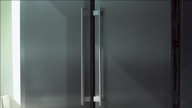 Refrigerator with two doors. Household utensils. Modern design of adjacent refrigerator with two large doors. Two large compartments for freezing and storage in double refrigerator