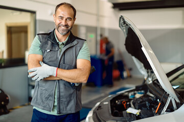 Portrait of happy auto repairman in a workshop.