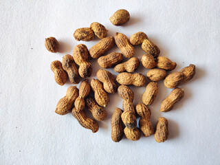 Fototapeta na wymiar Unpeeled peanuts isolated on white background. selective focus