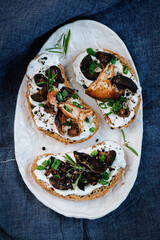Ceramic tray with mushroom sandwiches on dark bakground