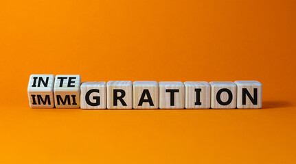 Turned a cube and changed the word 'immigration' to 'integration'. Beautiful orange background. Business concept. Copy space.