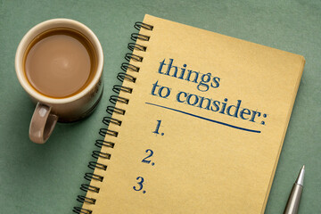 things to consider list - handwriting in a notebook with a cup of coffee, business planning concept