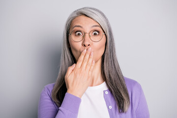 Silence. Photo of charming lovely shocked surprised mature lady hand cover mouth lips wear specs white shirt violet cardigan glasses isolated grey color background