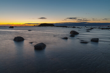 Fototapeta na wymiar Twilight sunset at summer. Baltic sea coast with boulders.