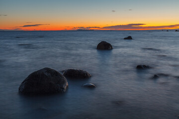 Fototapeta na wymiar Twilight sunset at summer. Baltic sea coast with boulders.