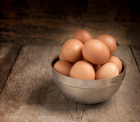 Chicken eggs in cup on wooden table
