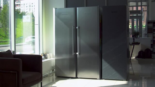 Refrigerator with two doors. Household utensils. Modern design of adjacent refrigerator with two large doors. Two large compartments for freezing and storage in double refrigerator