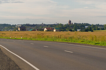 flat road against the background of the village in summer