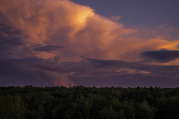 There are dramatic clouds in the dark sky as the sun sets. The sky is dominated by fuchsia, pink.