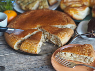 Guest food background.Homemade pie with cabbage and fish on the table with food. © Татьяна Пинкасевич