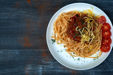 Traditional spaghetti pasta in a plate on a dark background . The view from the top .