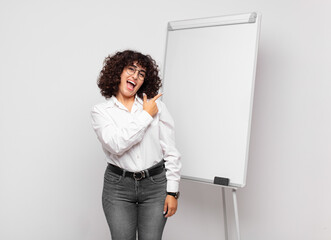  looking excited and surprised pointing to the side and upwards to copy space