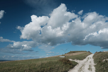 A chalk pathway along the South Downs Way in Sussex near Alfriston. Blue skies with low cumulus cloud