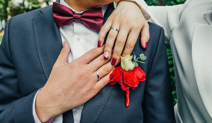 white gold wedding rings in a box and a bridal bouquet of delicate roses and greenery