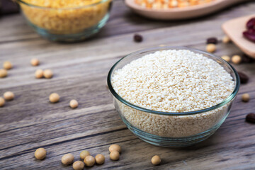 White sesame in bowl on wood table background. White sesame  seed in bowls.