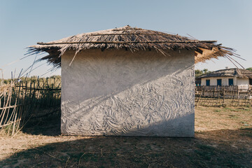 The wall of an old ethnic house. The wall texture. House of the hut. An ancient ethnic house with a thatched roof and a courtyard with a wicker fence. The traditional house of the Don Cossacks. 
