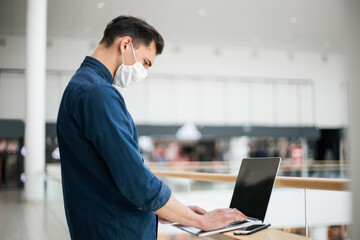 close up. a young man in a protective mask using a laptop