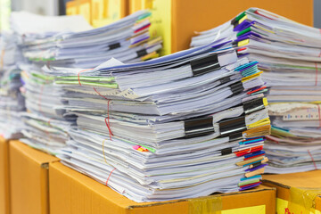 Pile of documents on desk stack up high waiting to be managed