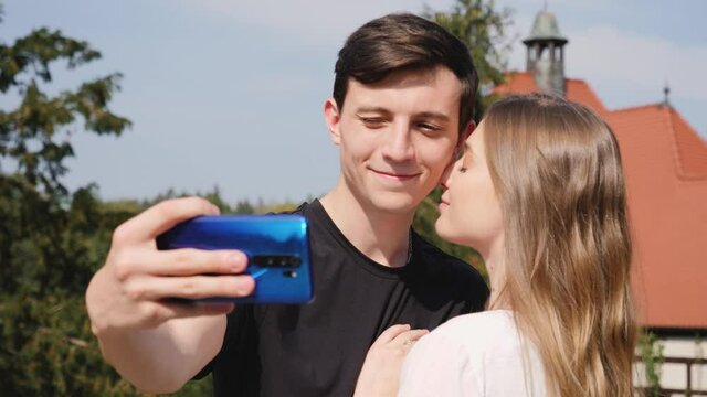 Young people couple tourists taking selfie pictures hugging on sightseeing landmark spending lovely time together