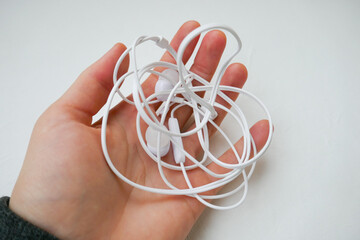 White headphones tangled, on a white background.