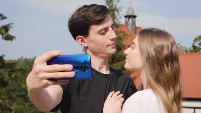 Young people couple tourists taking selfie pictures hug and kiss on sightseeing landmark spending lovely time together