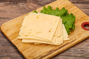 Sliced yellow cheese over board