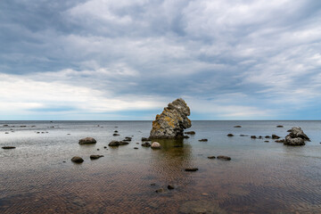 Famous rauk rock and stone formation in the shape of animal ape head with horizon of water and sky in the background at the island Gotland in Sweden.