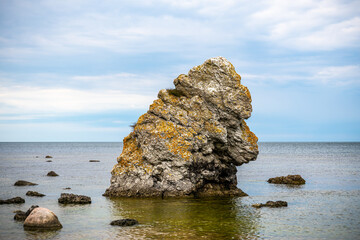 Famous rauk rock and stone formation in the shape of animal ape head with horizon of water and sky in the background at the island Gotland in Sweden.