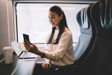 Focused young ethnic female sitting in train