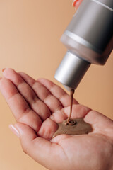 Girl pours chocolate shampoo into her hand