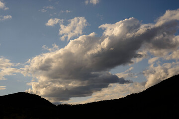 ciel nuageux au dessus de la crête d'une colline. Cloudy sky over the crest of a hill.
