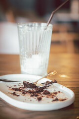 Dirty plate with cake crumbs leftovers and dirty a glass after enjoy eating