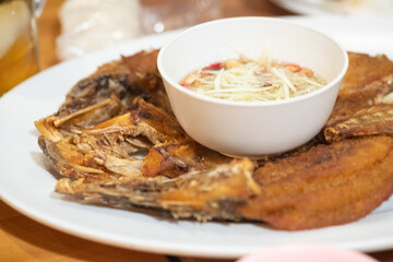 Seep fried sea bass mix fish sauce serve with spicy salad with green mango